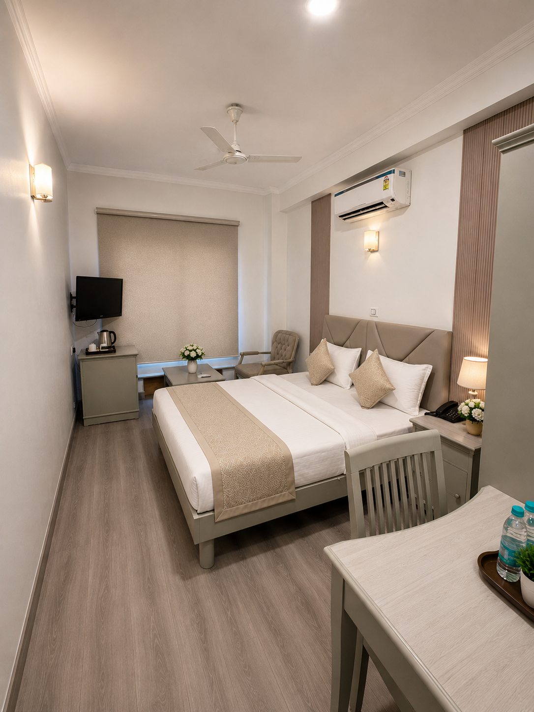Hotel Ambica Palace — deluxe king room with velvet sofa and warm sconce lighting