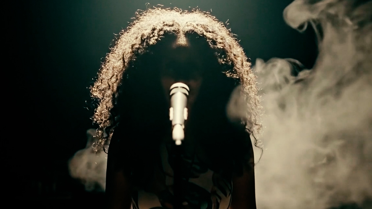 Silhouette at the microphone, halo of gold light