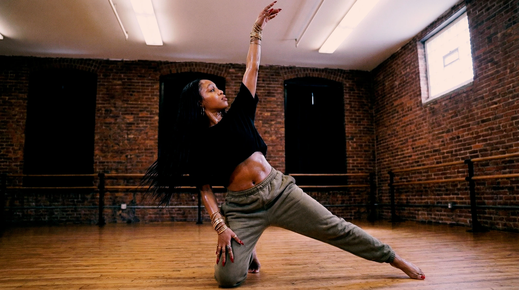 Dani dancing in a brick rehearsal studio