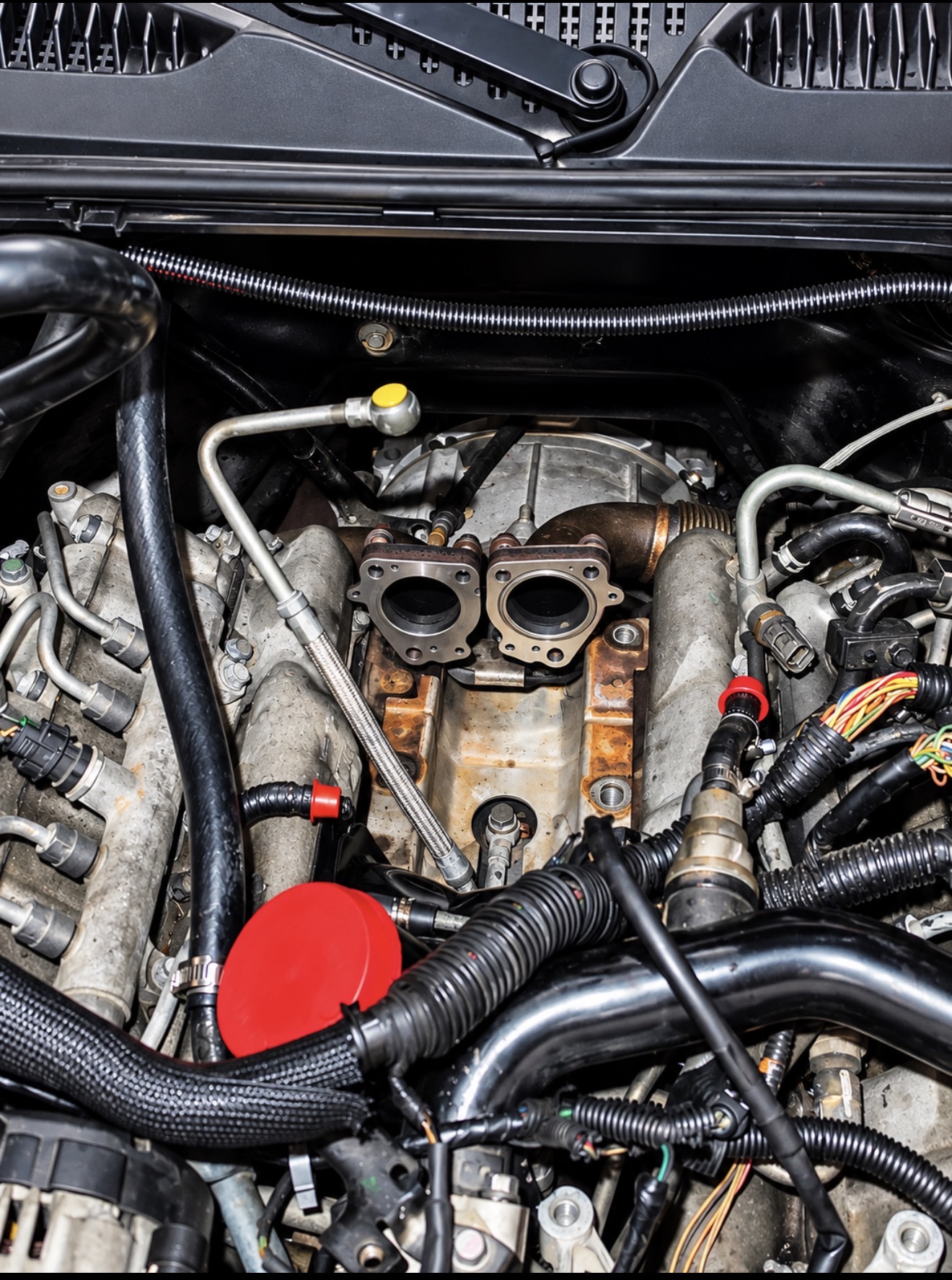 Custom red charge piping on a built engine by the water