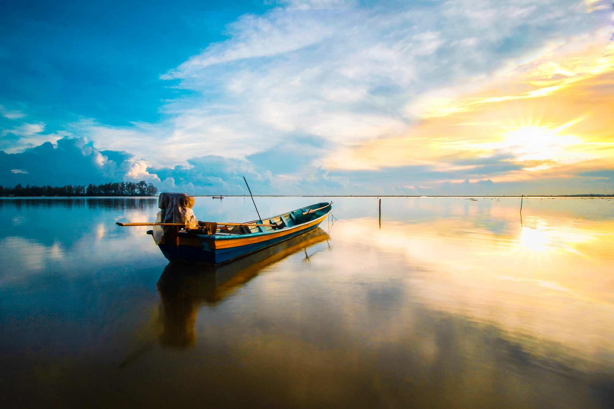 A boat on calm water at sunrise