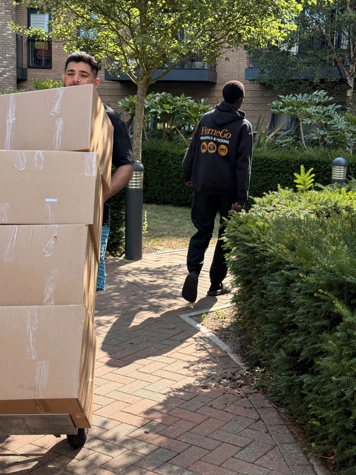 HomeGo Removals crew loading a Luton van at a modern London apartment block