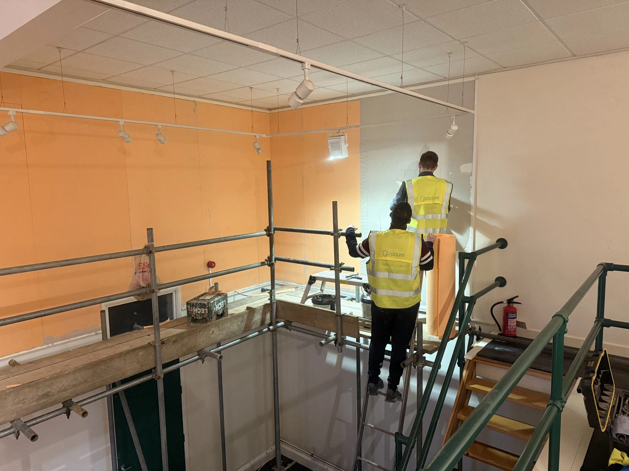 Procure Group technicians fitting insulated boards from a scaffold during remedial works