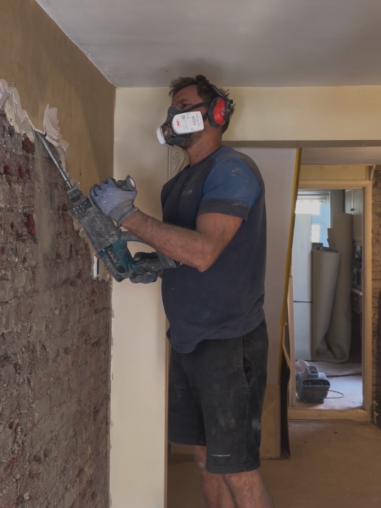 A Procure Group technician hacking off salt-contaminated plaster back to brickwork