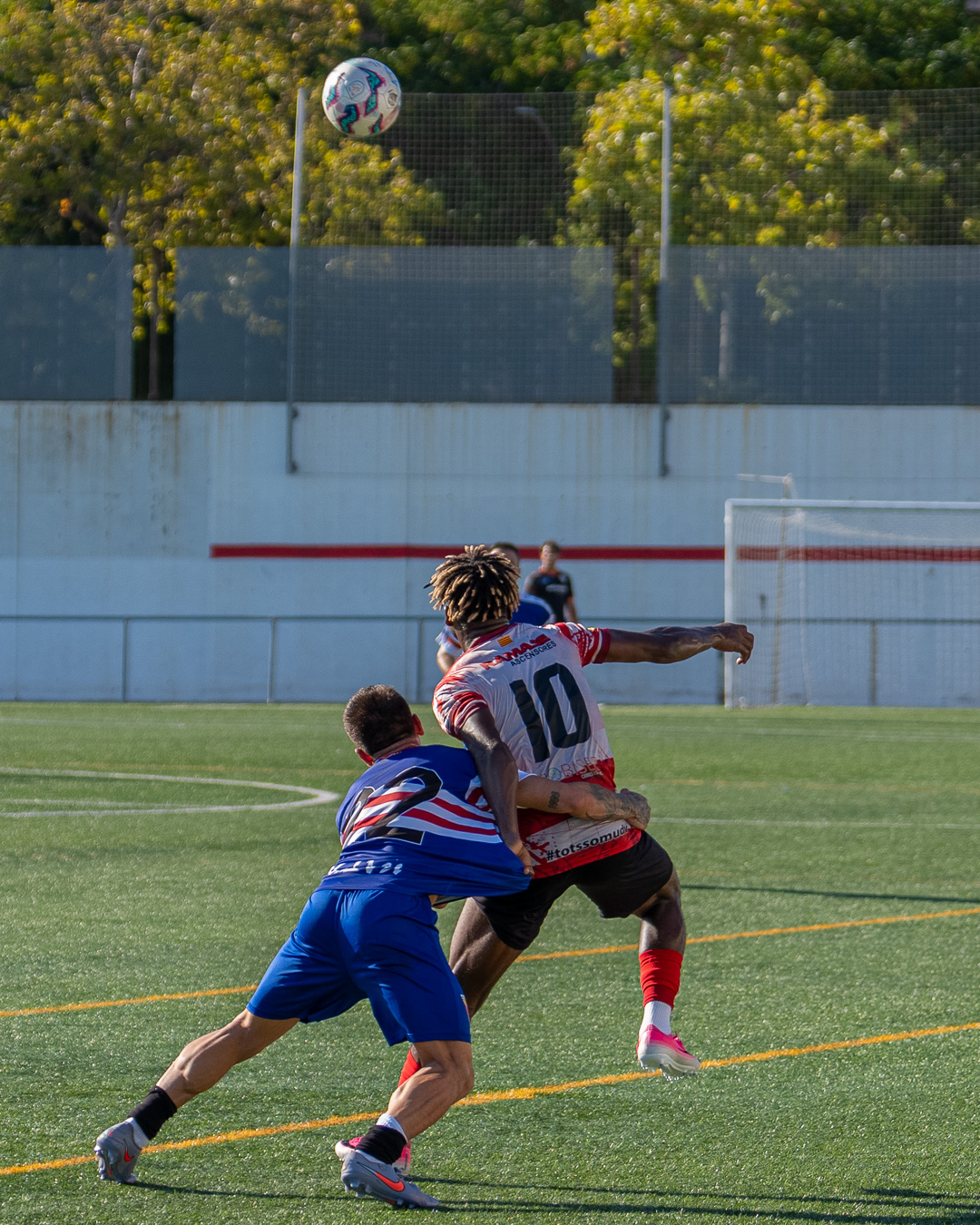 Sprint for possession — two defenders chasing down the striker