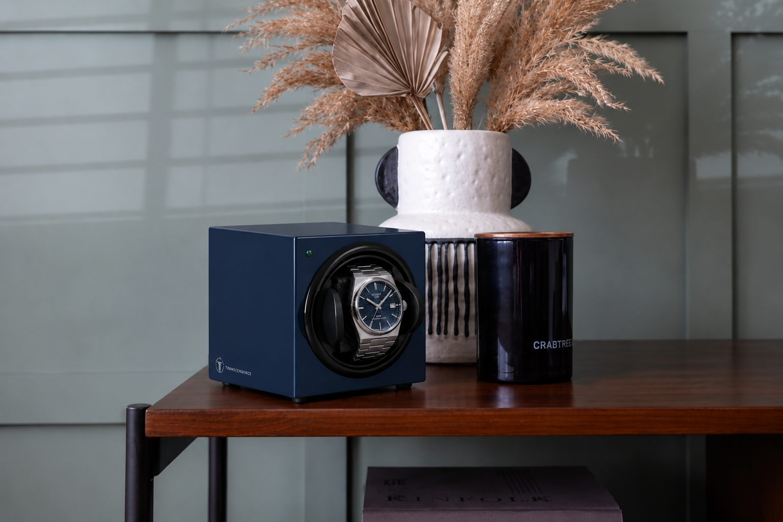 Transcendence watch winder in blue holding an automatic watch, styled on a shelf